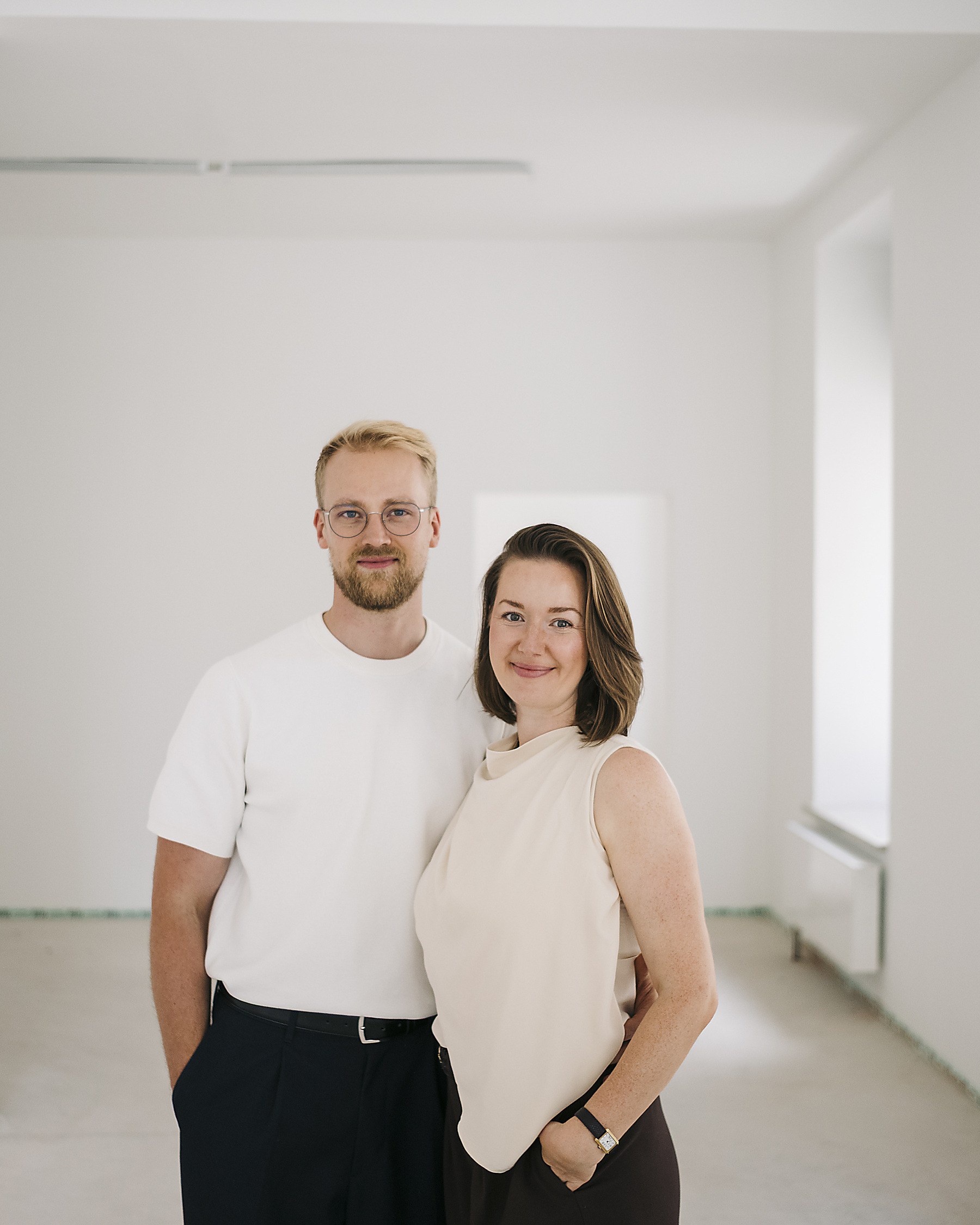 Jil und Christian Blumenauer nebeneinander in einer leeren Ladenfläche, beide lächelnd in die Kamera